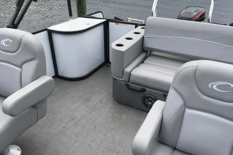 Slide: The Image of 2022 Crest Classic LX 240 boat interior with gray seating and cup holders. - 25