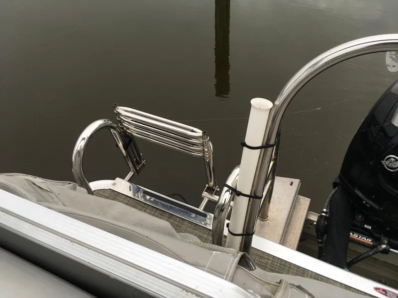 Slide: The Image of 2022 Crest Classic LX 240 boat ladder and motor on calm water. - 27