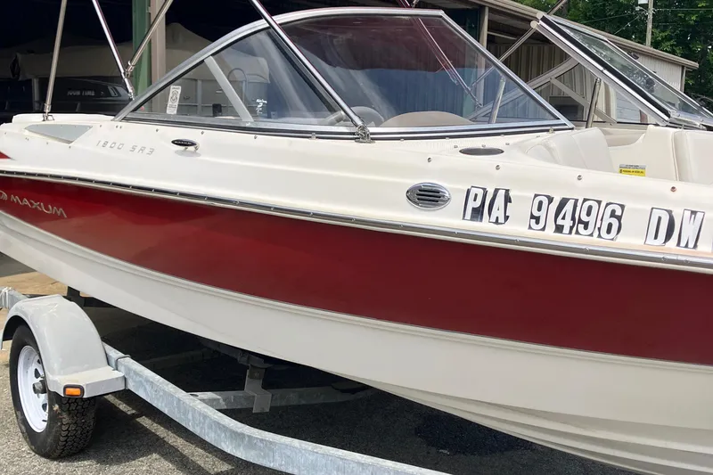 Slide: The Image of 2008 Maxum 1800SR boat with red and white exterior on a trailer. - 12