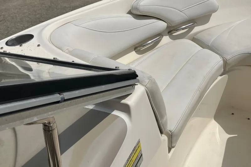 Slide: The Image of Interior of a 2008 Maxum 1800SR boat, featuring white seating and steering area. - 15