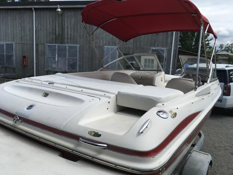 Slide: The Image of 2008 Maxum 1800SR boat with red canopy, parked on trailer near wooden building. - 5