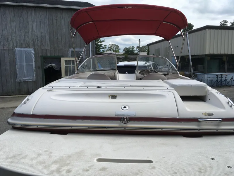 Slide: The Image of 2008 Maxum 1800SR boat with red canopy, parked near wooden building. - 6