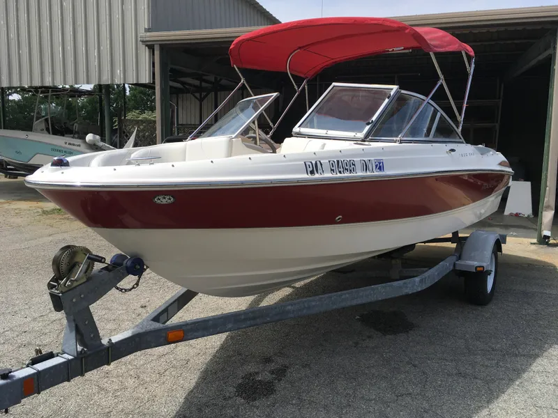 Slide: The Image of 2008 Maxum 1800SR boat with red canopy on trailer, parked near a shed. - 9