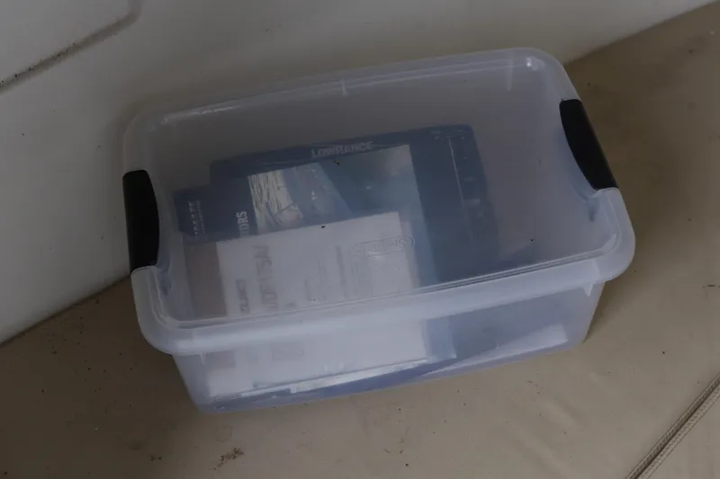 Slide: The Image of Clear plastic storage box with documents inside, related to Angler 2100WA 2003 model. - 11