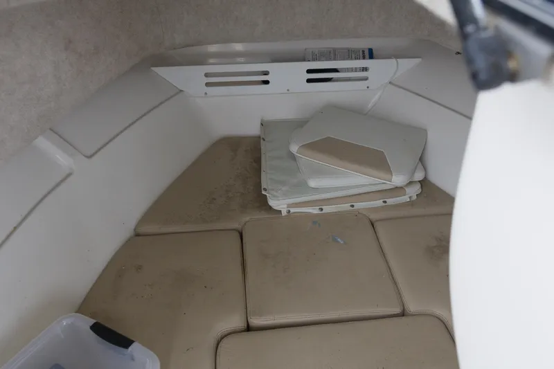 Slide: The Image of 2003 Angler 2100WA boat interior with beige cushions and storage area. - 12