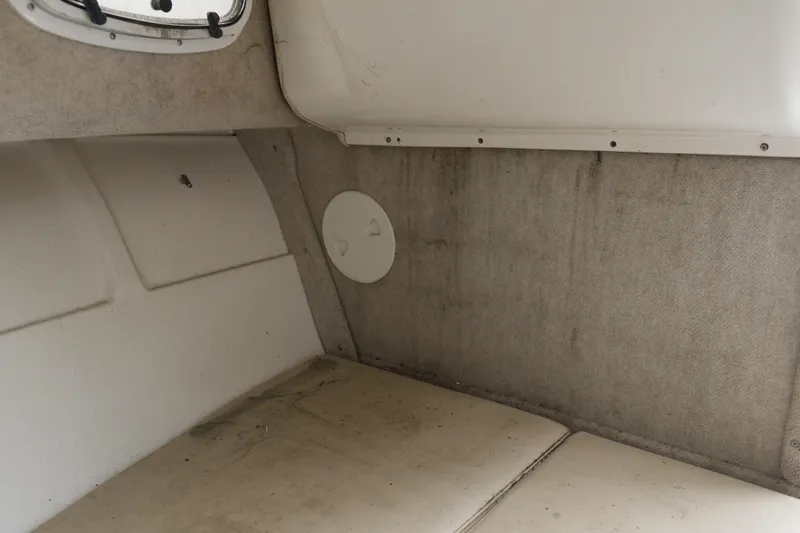 Slide: The Image of 2003 Angler 2100WA boat cabin interior with beige upholstery and wall paneling. - 13