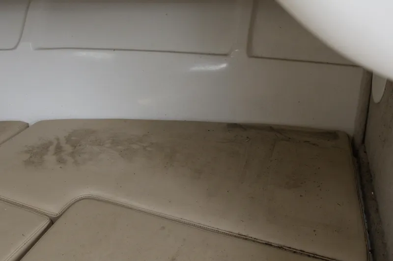 Slide: The Image of 2003 Angler 2100WA boat interior with worn beige cushions. - 15