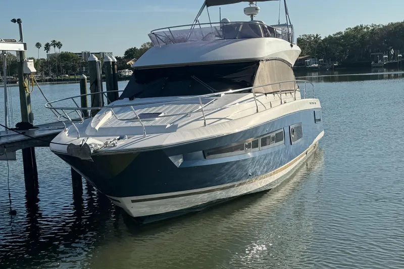 Slide: The Image of Luxury 2015 Prestige 450 yacht docked in serene marina setting. - 2