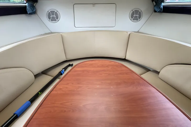 Slide: The Image of 2006 Bayliner 265 interior with beige seating and wooden table. - 4