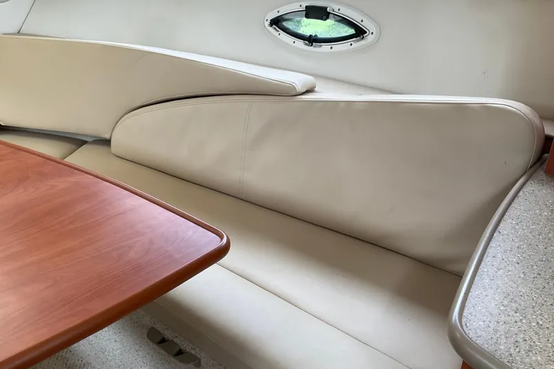 Slide: The Image of 2006 Bayliner 265 interior with beige seating and wooden table. - 5