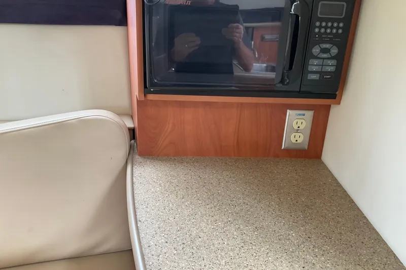 Slide: The Image of 2006 Bayliner 265 interior with microwave, countertop, and electrical outlet. - 6
