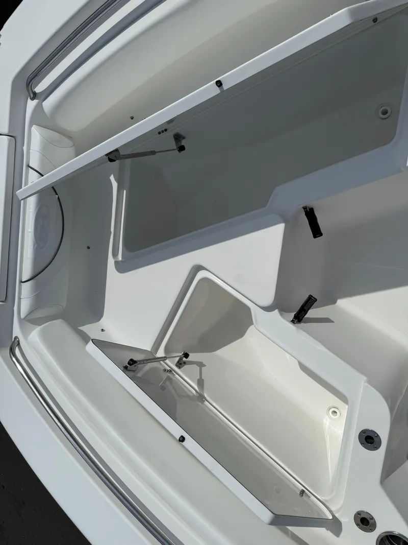 Slide: The Image of 2014 Sea Hunt Ultra 211 boat storage compartments open, showcasing interior space. - 10