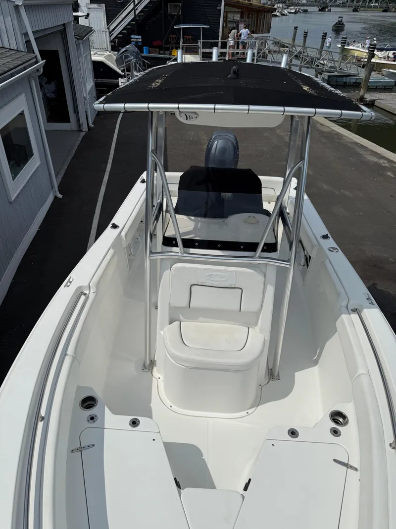 Slide: The Image of 2014 Sea Hunt Ultra 211 boat docked, featuring a spacious deck and T-top canopy. - 9