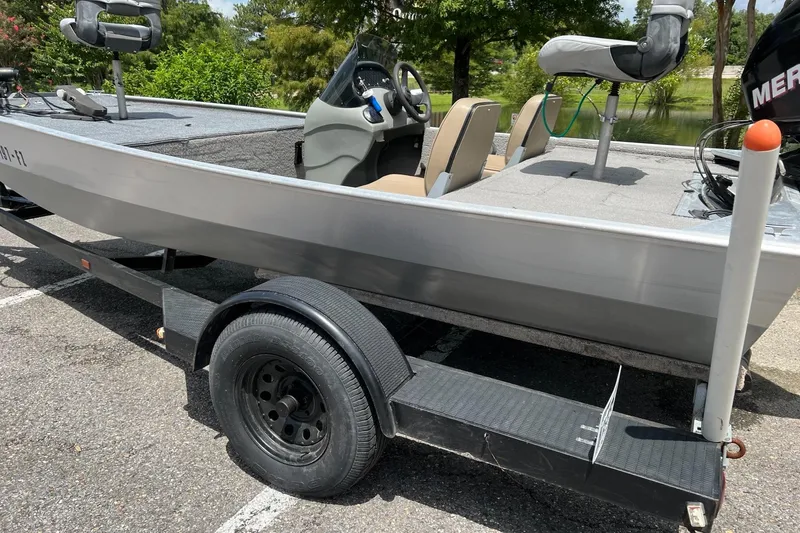Slide: The Image of 2012 Tracker Pro165 boat on trailer, parked near a lake. - 4