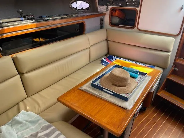 Slide: The Image of 1990 Tiara Yachts 31 Open interior with beige seating and wooden table. - 10