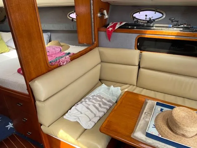 Slide: The Image of 1990 Tiara Yachts 31 Open cabin interior with beige seating and wooden accents. - 11