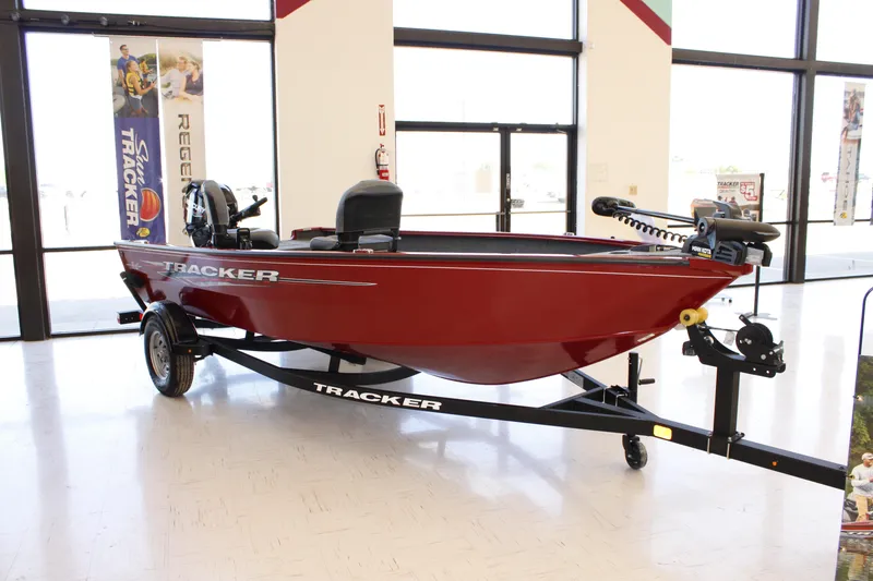 The Image of 2025 Tracker Super Guide V-16 T boat in showroom, red hull, on trailer. - 0