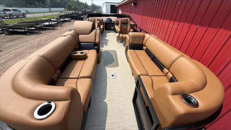 Slide: The Image of 2025 Regency 230 LE3 pontoon boat with luxurious tan seating and cup holders. - 3