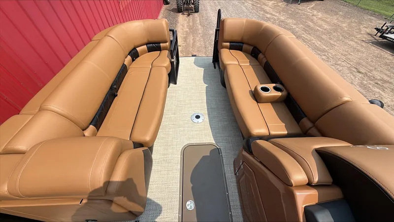 Slide: The Image of Luxurious seating on 2025 Regency 230 LE3 pontoon boat with tan upholstery and cup holders. - 6