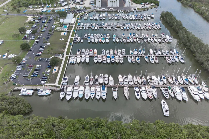 Slide: The Image of Aerial view of a marina with numerous boats docked, surrounded by lush greenery. - 116