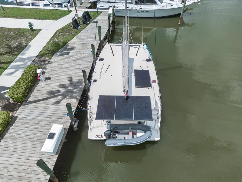 Slide: The Image of Aerial view of 2011 Leopard 38 catamaran docked, featuring solar panels and a small dinghy. - 12