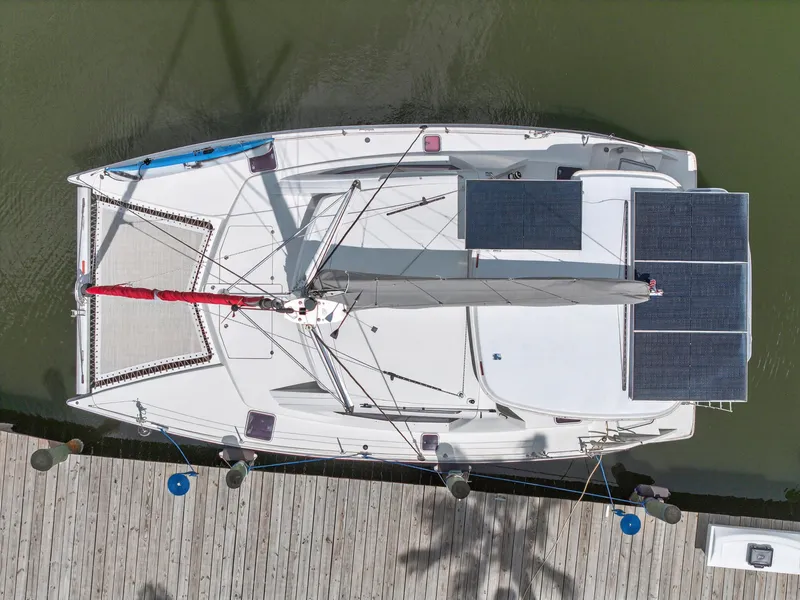 Slide: The Image of Overhead view of a 2011 Leopard 38 catamaran docked, featuring solar panels and a red sail. - 13