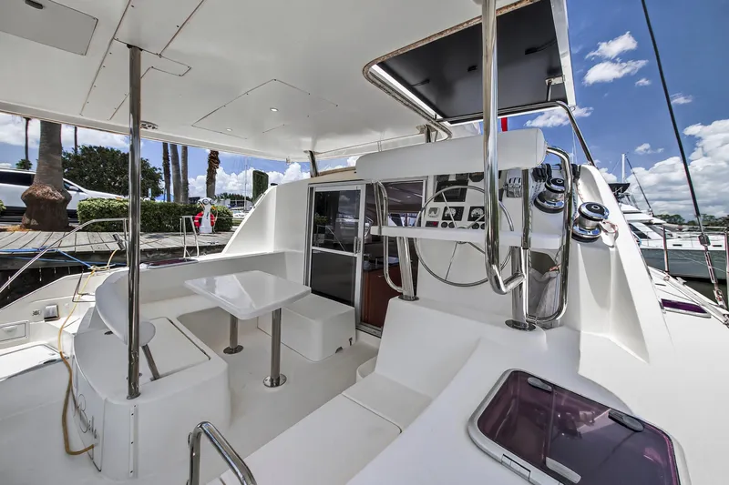 Slide: The Image of 2011 Leopard 38 yacht cockpit with seating, table, and steering wheel under a clear blue sky. - 15