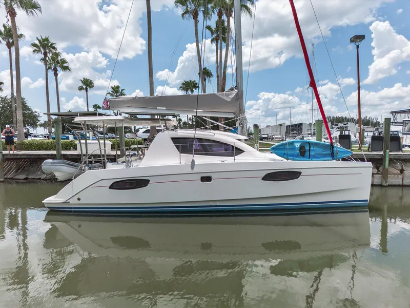 Slide: The Image of 2011 Leopard 38 catamaran docked, surrounded by palm trees and clear skies. - 2