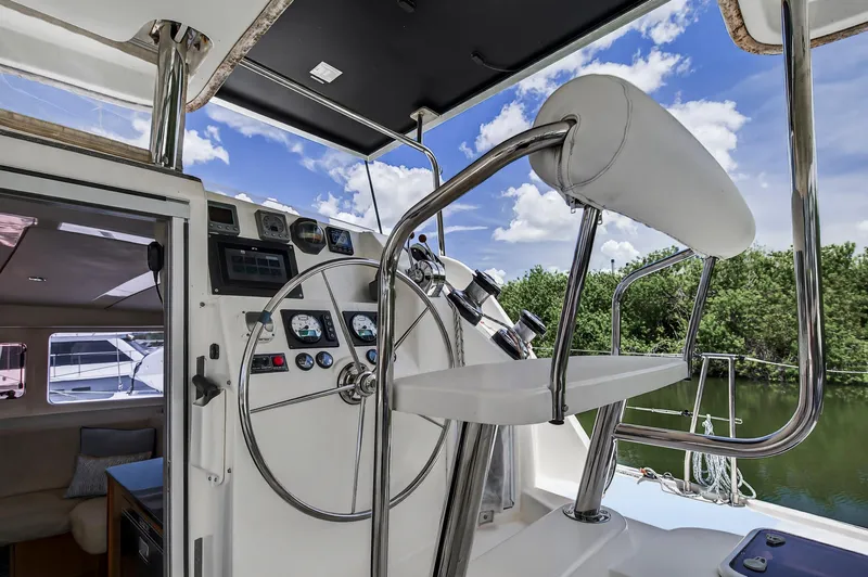 Slide: The Image of Helm of 2011 Leopard 38 catamaran with steering wheel and controls, under blue sky. - 22