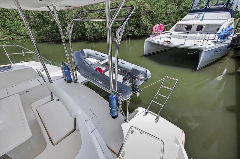 Slide: The Image of Leopard 38 catamaran with dinghy and ladder, docked in a serene waterway. - 31