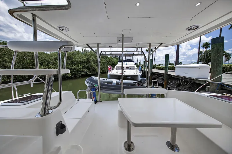 Slide: The Image of 2011 Leopard 38 yacht interior with seating and table, docked near lush greenery. - 38