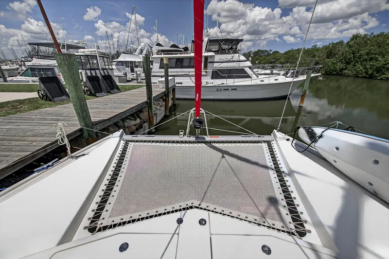 Slide: The Image of 2011 Leopard 38 catamaran docked at marina, surrounded by other boats under a cloudy sky. - 42