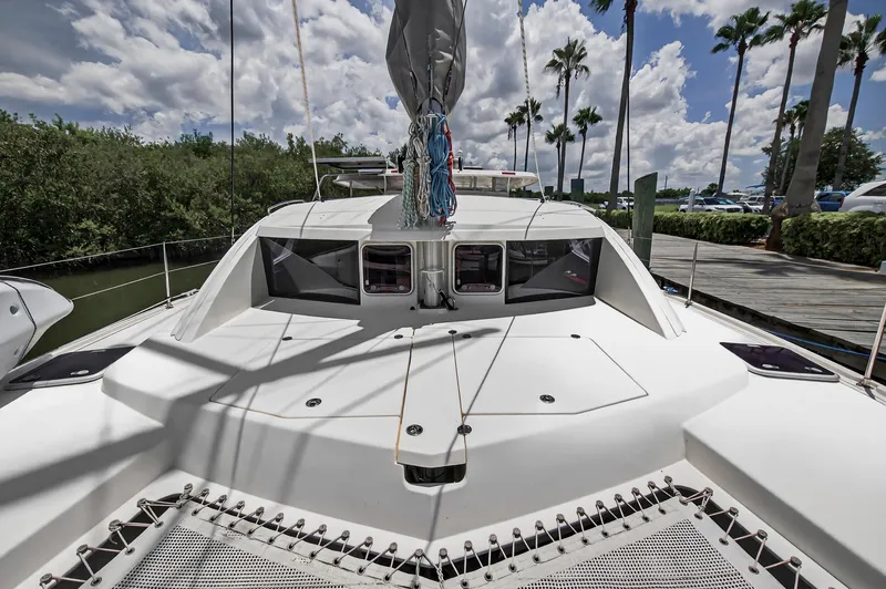 Slide: The Image of 2011 Leopard 38 catamaran docked, featuring spacious deck and tropical surroundings. - 45