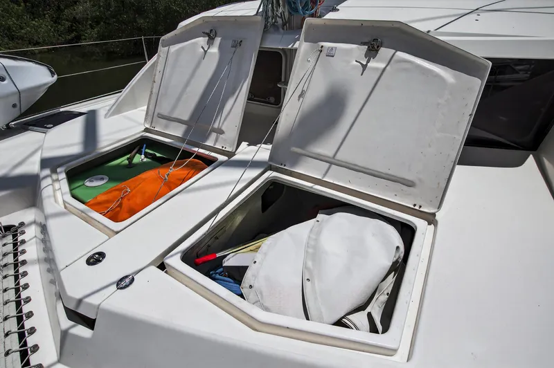 Slide: The Image of Open storage compartments on a 2011 Leopard 38 catamaran deck, revealing various boating equipment. - 47