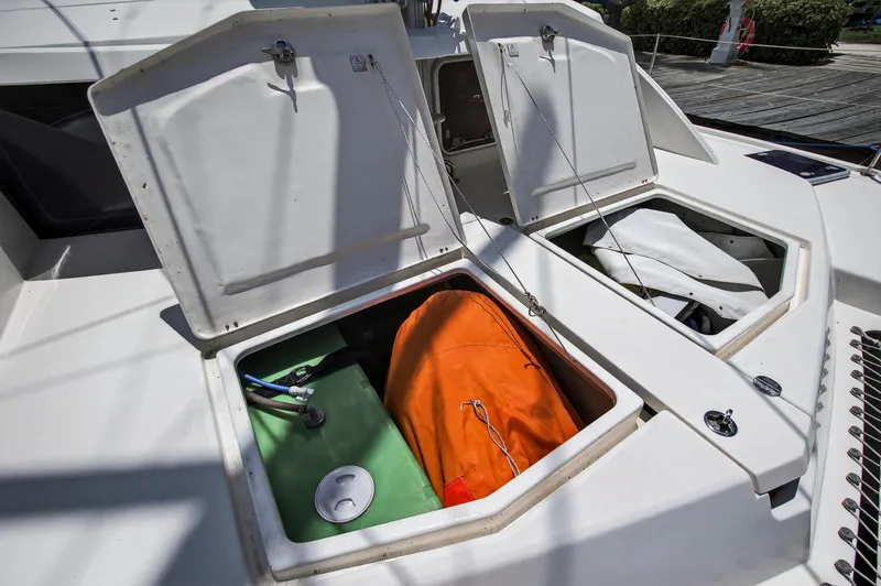 Slide: The Image of Open storage compartments on a 2011 Leopard 38 catamaran, revealing equipment and an orange bag. - 49