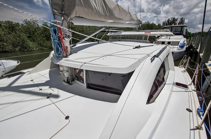 Slide: The Image of 2011 Leopard 38 catamaran docked, featuring sleek design and rigging, under a partly cloudy sky. - 52