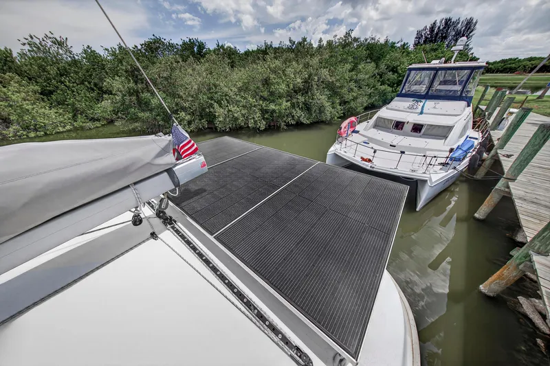 Slide: The Image of 2011 Leopard 38 catamaran with solar panels docked beside another boat. - 57