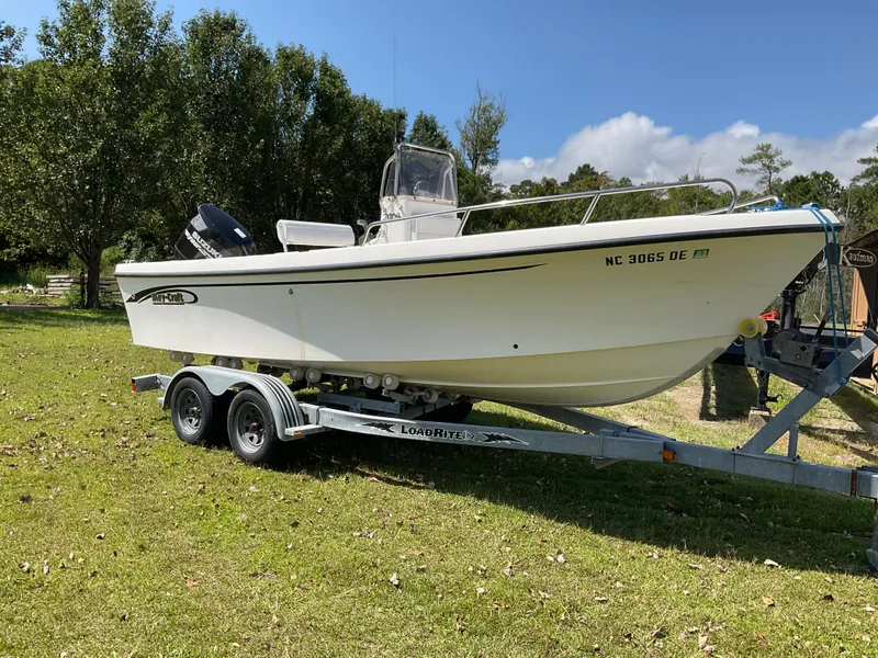 The Image of 2007 May-Craft 2000CC boat on trailer, parked on grassy area with trees in background. - 1