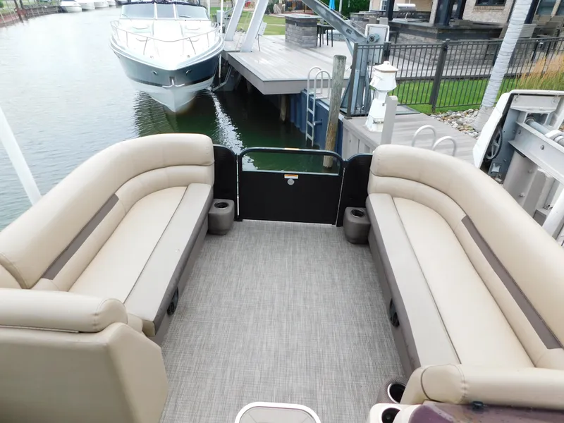Slide: The Image of 2019 Godfrey SWEETWATER 2186 SB pontoon boat interior with beige seating and docked nearby. - 21
