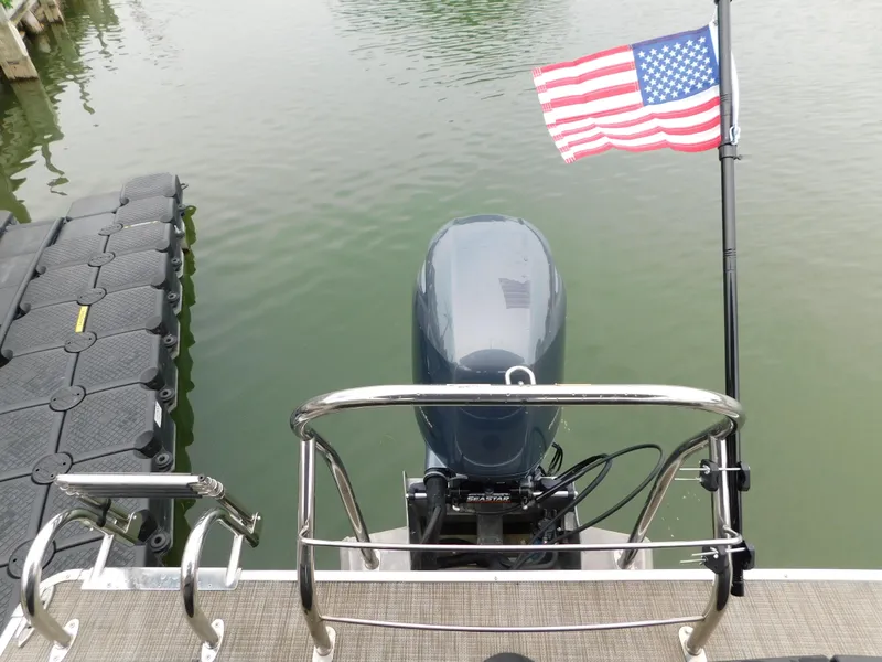 Slide: The Image of 2019 Godfrey SWEETWATER 2186 SB boat with American flag and outboard motor. - 7
