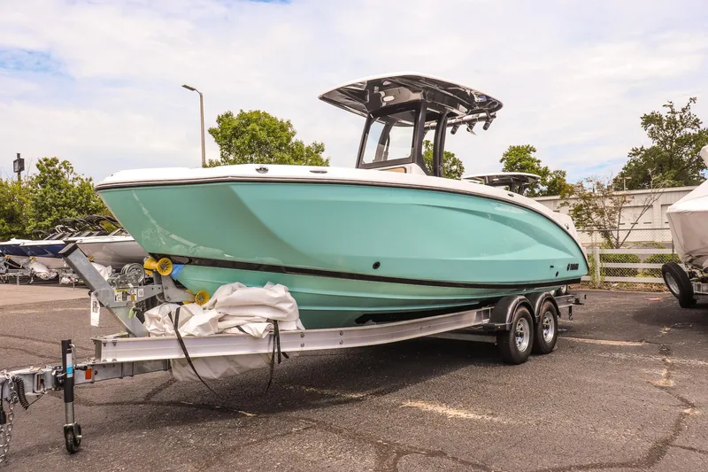 The Image of 2025 Yamaha Boats 255 FSH Sport E on trailer, parked outdoors, showcasing sleek design. - 0