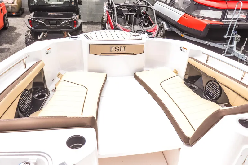 Slide: The Image of 2025 Yamaha Boats 255 FSH Sport E interior with beige seating and cup holders. - 13