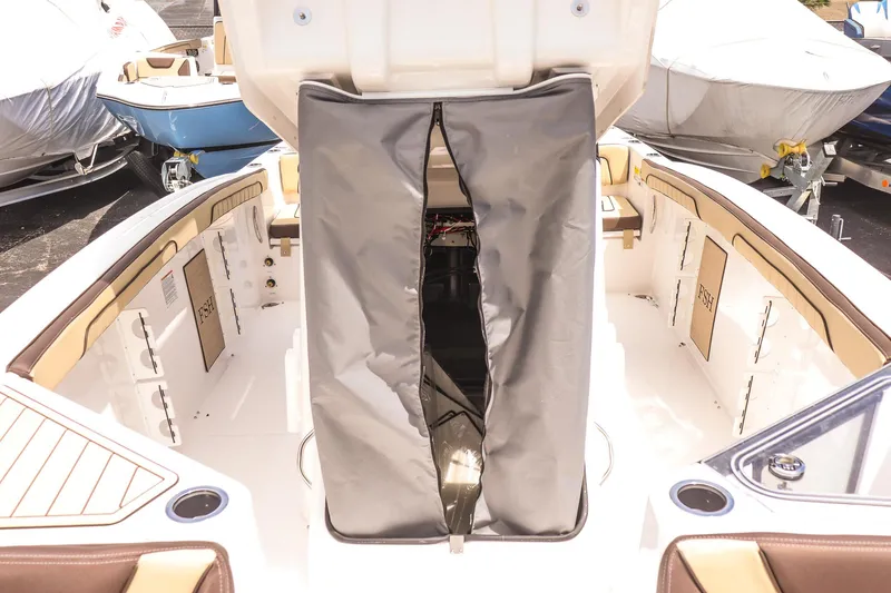 Slide: The Image of 2025 Yamaha Boats 255 FSH Sport E interior with open storage compartment and seating. - 15