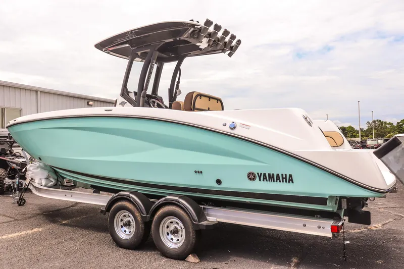 Slide: The Image of 2025 Yamaha Boats 255 FSH Sport E on trailer, mint green hull, parked outdoors. - 6