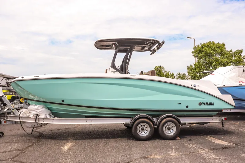 Slide: The Image of 2025 Yamaha Boats 255 FSH Sport E in teal on trailer, side view. - 7
