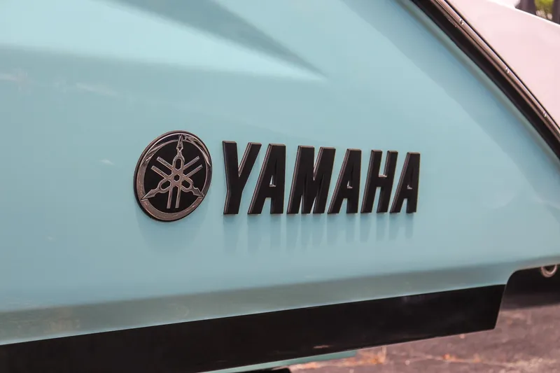 Slide: The Image of Yamaha logo on 2025 Yamaha Boats 255 FSH Sport E, light blue hull. - 9