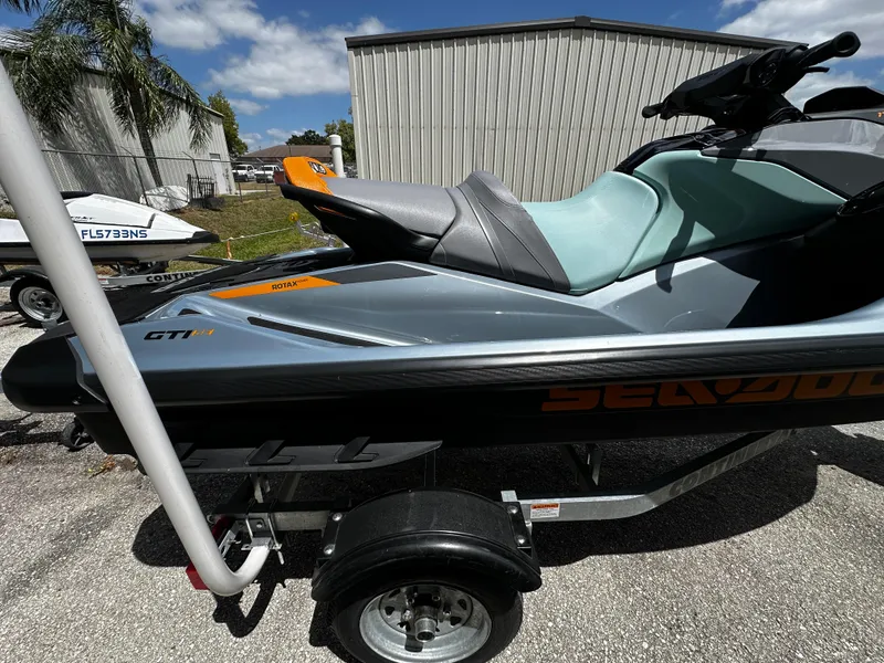 Slide: The Image of 2023 Sea-Doo GTI SE 170 jet ski on trailer, parked outdoors. - 13