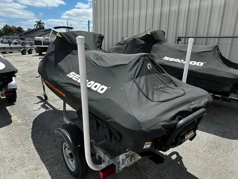 Slide: The Image of 2023 Sea-Doo GTI SE 170 jet ski covered, parked on a trailer outdoors. - 2