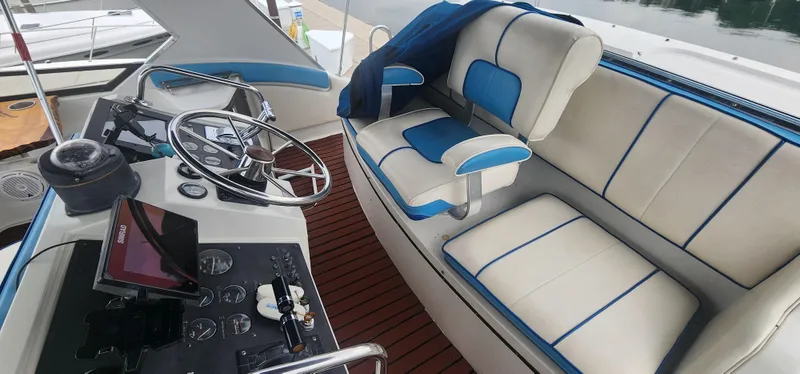 Slide: The Image of 1990 Carver 38 Santego boat interior with steering wheel, control panel, and cushioned seating. - 17