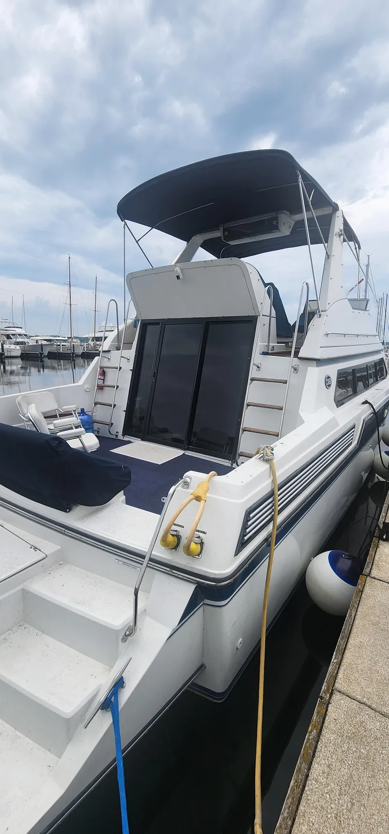 Slide: The Image of 1990 Carver 38 Santego yacht docked at marina under cloudy sky. - 2